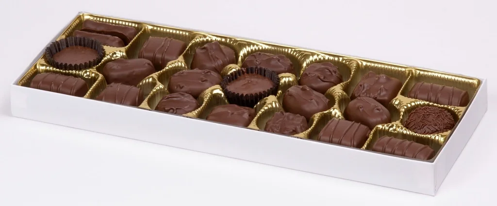 An open rectangular gift box filled with assorted chocolates