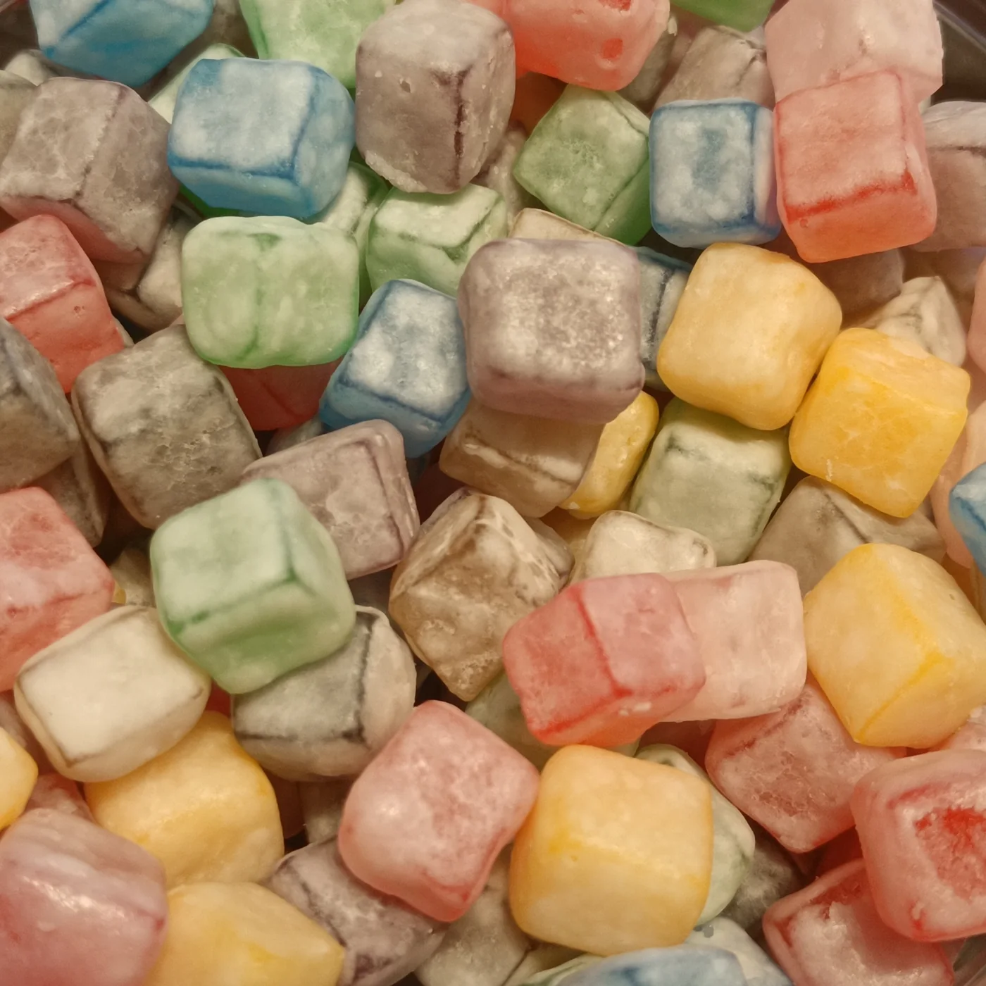 Colorful cube-shaped gummy candy arranged on a white surface