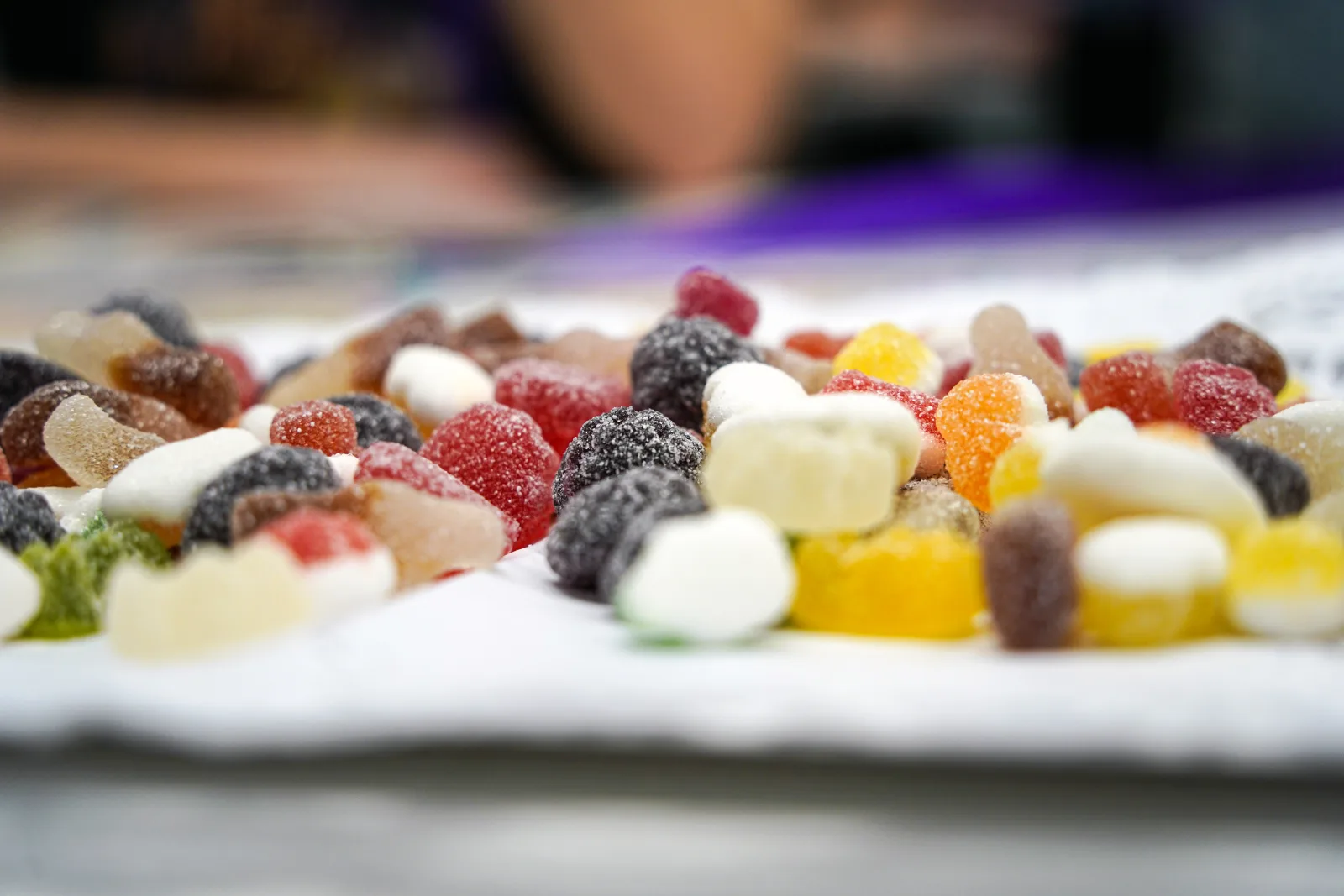 Colorful gummy candies scattered across a white surface