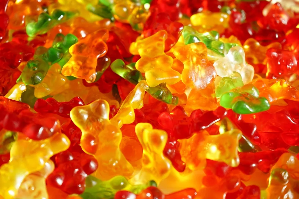 Colorful gummy bears spread across a bright surface