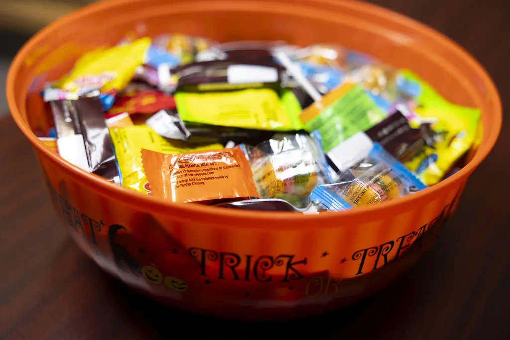 Assorted wrapped candy in an orange serving bowl