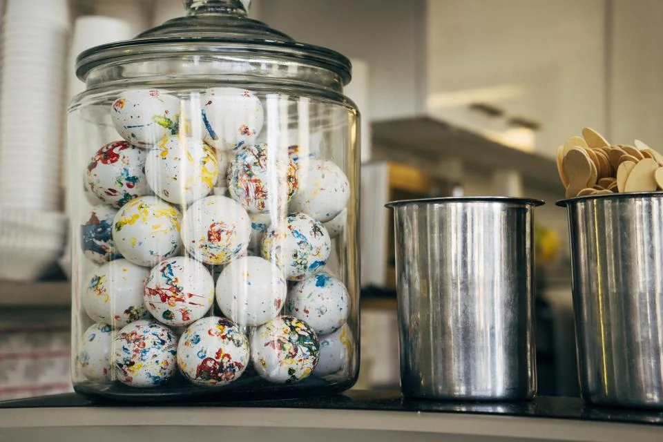 A clear glass jar filled with wrapped candy